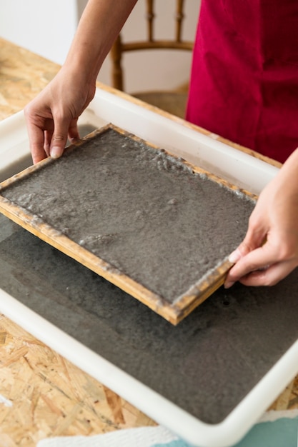 Main de femme tenant la moisissure avec de la pâte pour faire du papier