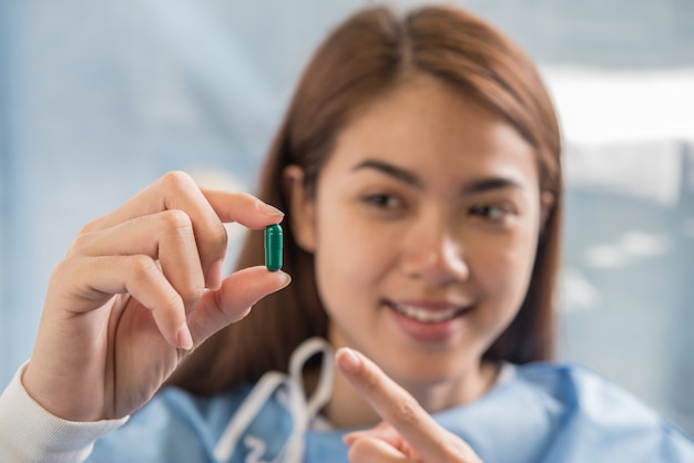 main de femme tenant une pilule prendre des médicaments selon l&#39;ordre du docteur