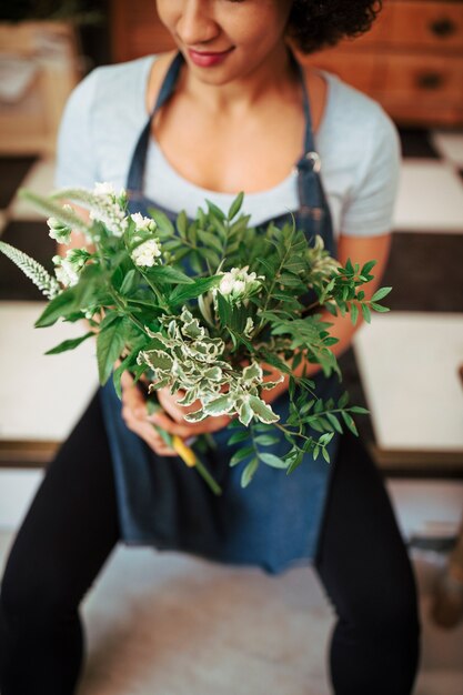 Main de femme tenant une plante à fleurs fraîches