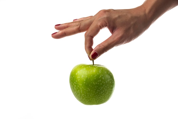 Main de femme tenant une pomme unique sur blanc.