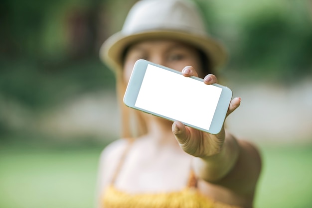main de femme tenant le téléphone portable, smartphone avec écran blanc
