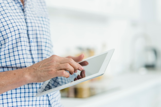 Main de femme touchant l&#39;écran de la tablette numérique