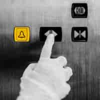 Photo gratuite main gantée appuyant sur un bouton d'ascenseur pour éviter la contamination par le coronavirus