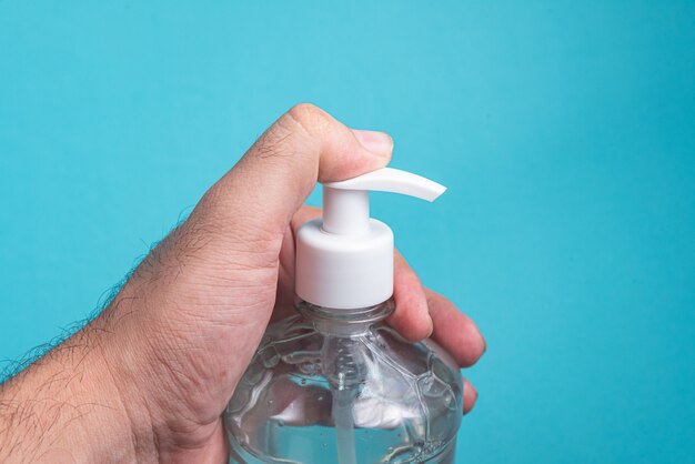 Main de l'homme dans un récipient avec du gel d'alcool