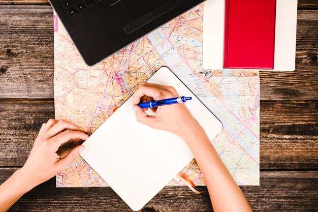 Main de l&#39;homme écrit sur le bloc-notes avec un stylo sur une table en bois