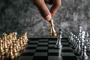 Photo gratuite main d'un homme jouant aux échecs pour la planification d'entreprise et la comparaison de métaphore, mise au point sélective