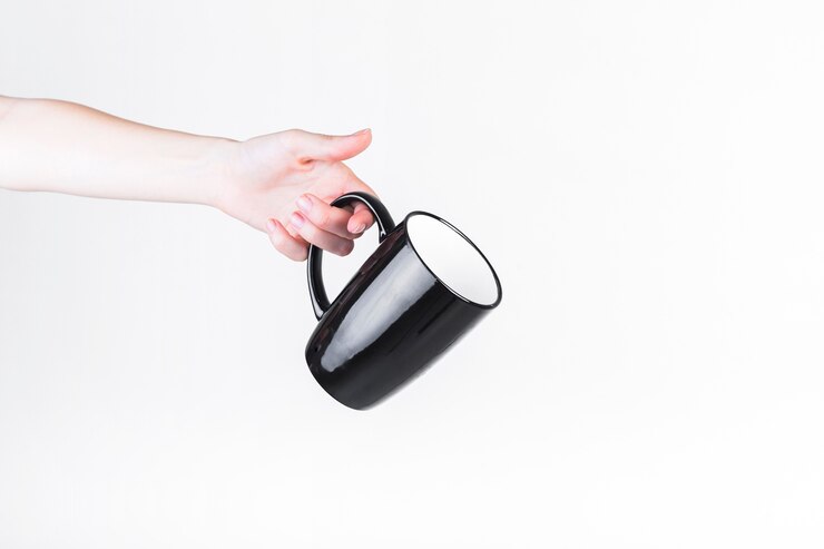 Photo gratuit main de l&#39;homme tenant une tasse noire sur fond blanc
