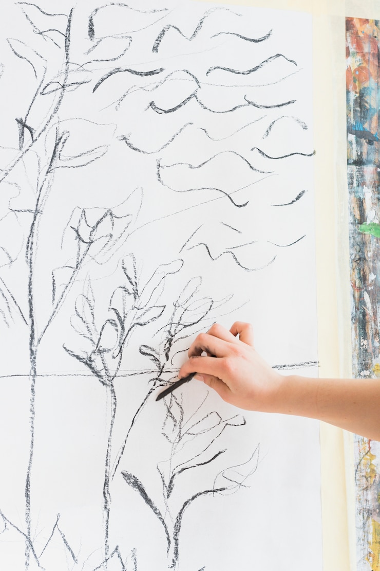 Photo gratuit main humaine, dessin sur toile à l&#39;aide d&#39;un bâton de charbon