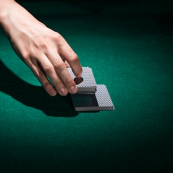 Main humaine tenant une carte de poker au casino