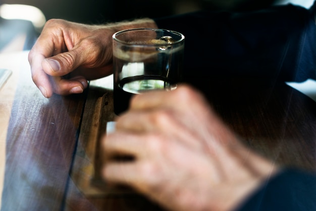 Main humaine avec un verre de boisson