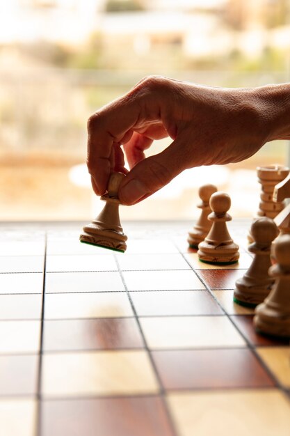 Main jouant aux échecs sur un plateau classique