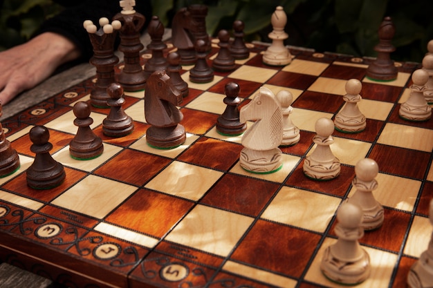 Main jouant aux échecs sur un plateau classique