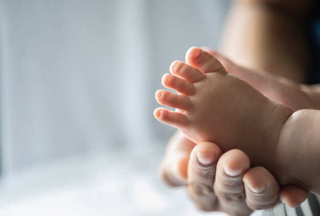 La main de la mère ornait les pieds du nouveau-né.