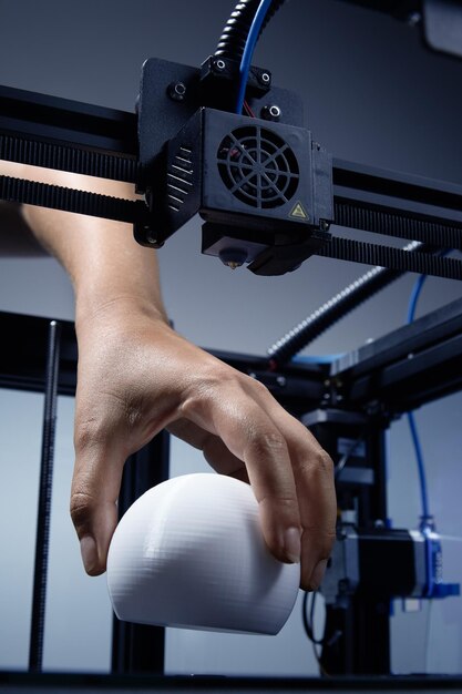 Une main non sexiste se levant de la structure Objet rond imprimé en 3d fabriqué à partir de plastique recyclé Concept futuriste de nouvelles possibilités de travail pour les petites entreprises par impression 3D Jpg photo