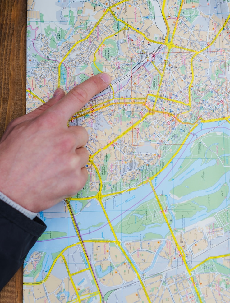 Photo gratuit main de personne pointant sur la carte