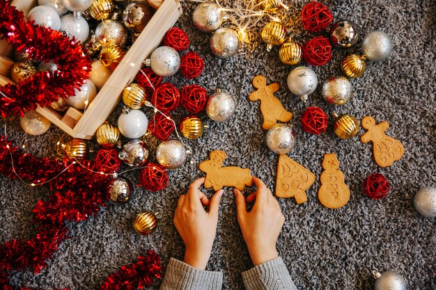 Main en plaçant la décoration de pain d&#39;épice et de noël