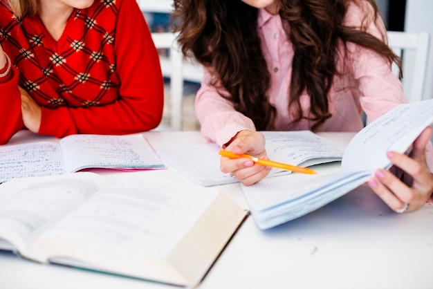 Main, pointant sur des notes dans le cahier