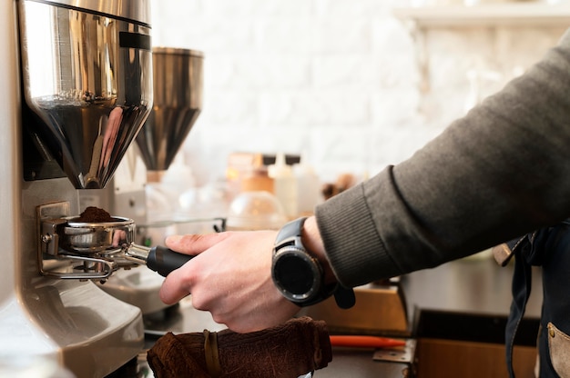 Main de près avec une montre préparant du café