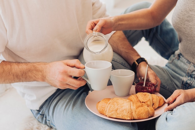 Main servant du lait avec un croissant