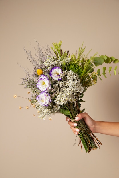 Photo gratuite main tenant un arrangement de fleurs boho