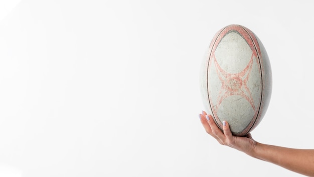 Main tenant le ballon de rugby avec espace copie