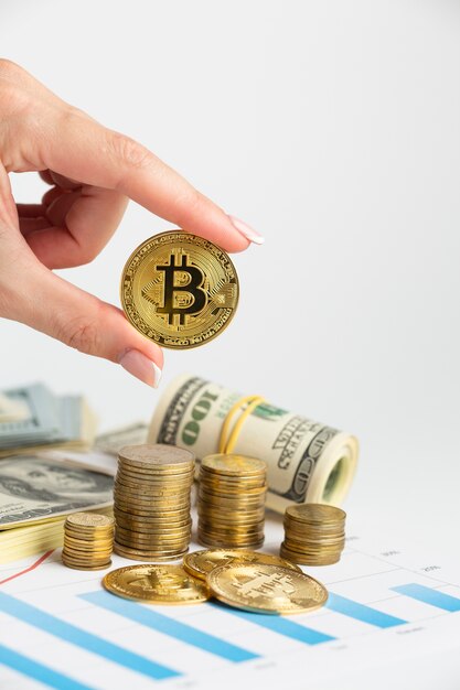 Main tenant bitcoin au-dessus de la pile de pièces