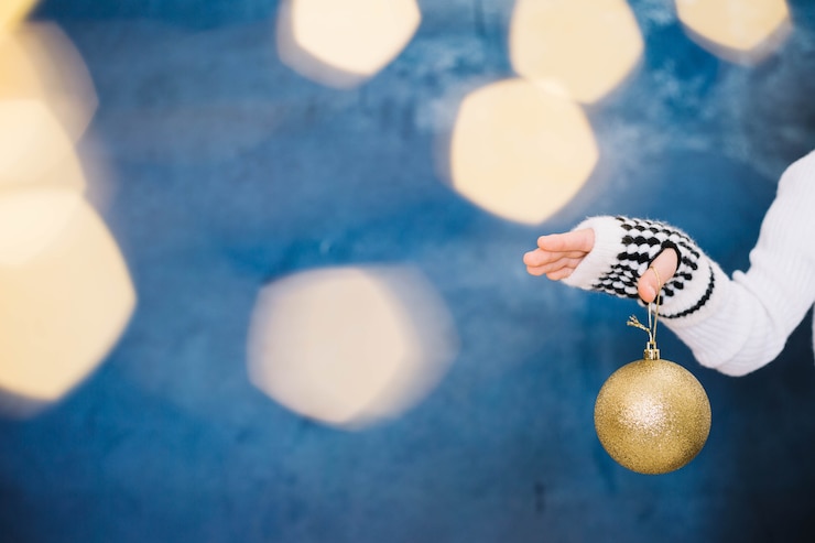 Photo gratuit main tenant des boules de noël