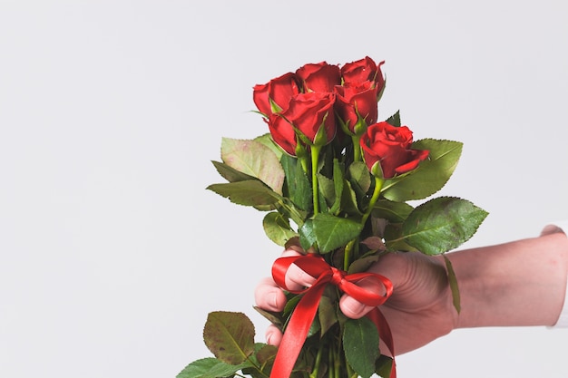 Photo gratuite une main tenant un bouquet de roses