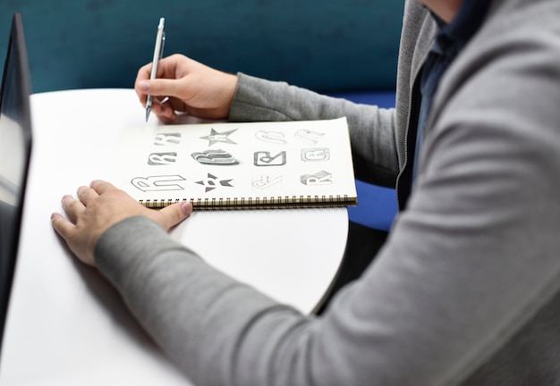 Main tenant le cahier avec le logo de marque Drew Idées de conception créative