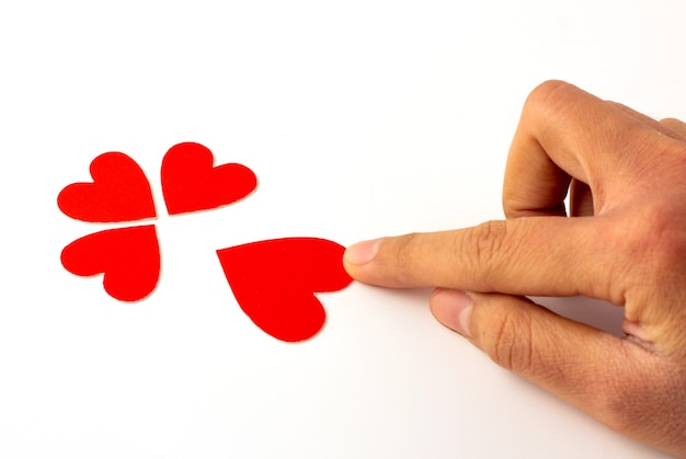 Main tenant du papier rouge en forme de coeur isolé, concept d'amour et de la saint-valentin.