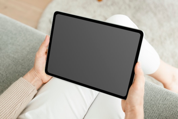 Photo gratuite main tenant une tablette numérique avec écran noir vierge