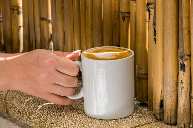 Main tenant une tasse de café