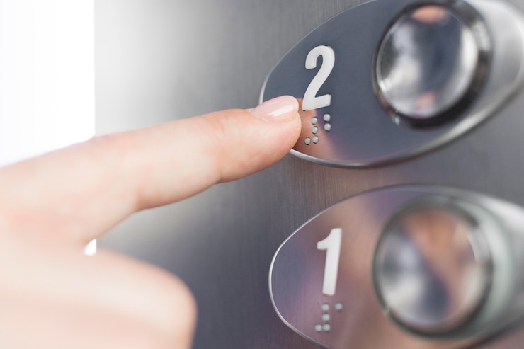 Photo gratuit main touchant la figure braille ascenseur