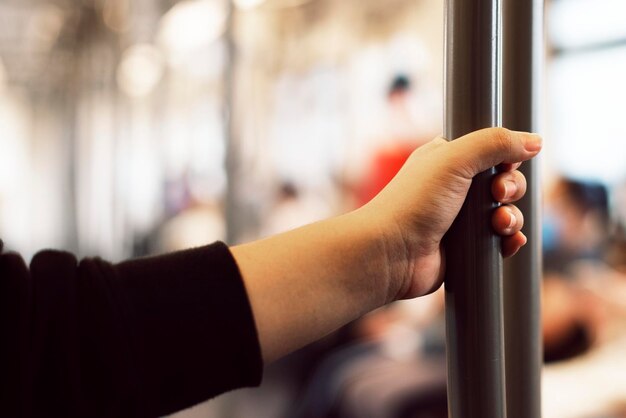 Main touchant une main courante de train contaminée par un coronavirus