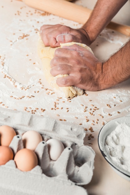 Photo gratuite main en train de pétrir la pâte sur le comptoir de la cuisine