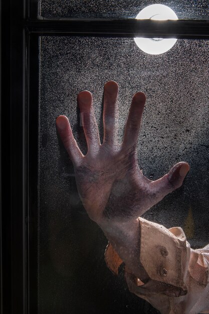 Main de zombie effrayant sur une fenêtre