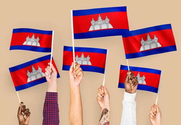 Mains agitant des drapeaux du Cambodge