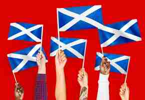 Photo gratuite mains agitant des drapeaux de l'ecosse