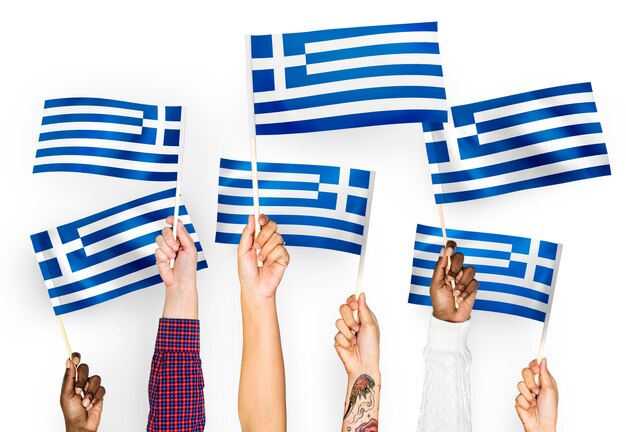 Mains agitant des drapeaux de la Grèce