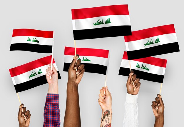 Mains agitant des drapeaux de l&#39;Irak