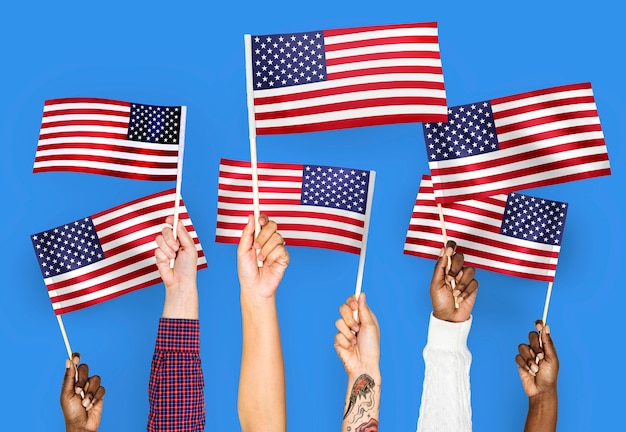 Mains agitant des drapeaux des États-Unis