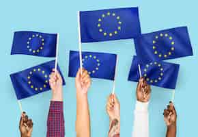 Photo gratuite mains agitant des drapeaux de l'union européenne