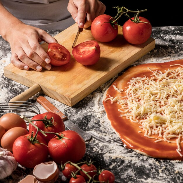 Mains d'angle élevé coupant la tomate