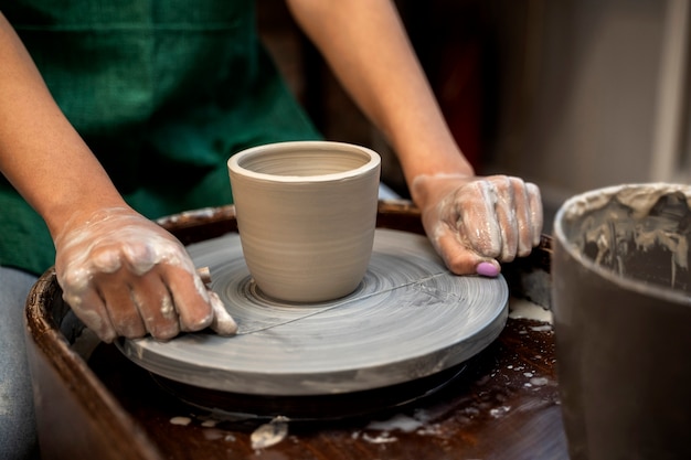 Mains à angle élevé faisant de la poterie