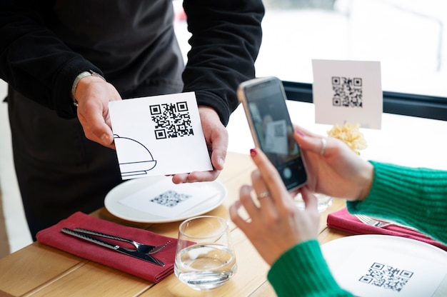 Photo gratuite mains à angle élevé scannant le code qr