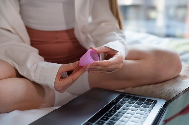 Photo gratuite mains à angle élevé tenant une coupe menstruelle