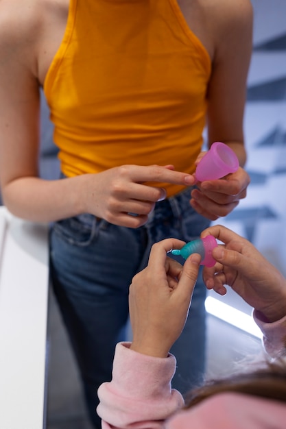 Mains à angle élevé tenant des coupes menstruelles