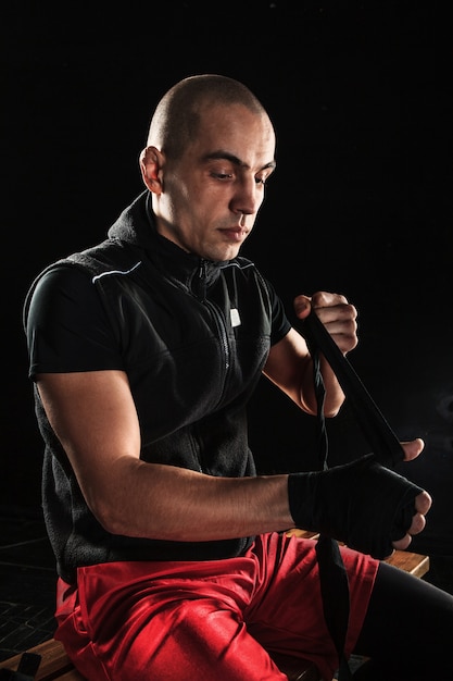 Les mains avec un bandage de kickboxing formation homme musclé sur fond noir