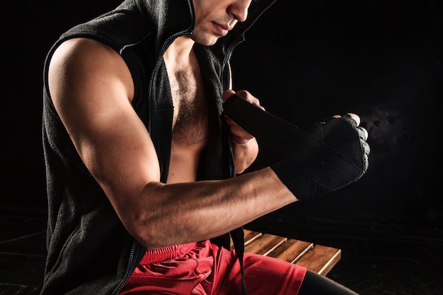 mains avec bandage de kickboxing formation homme musclé sur fond noir