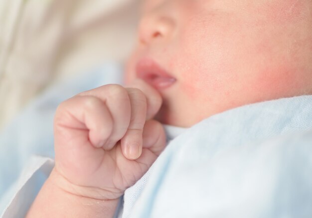 Les mains des bébés. L&#39;enfant suce les poings